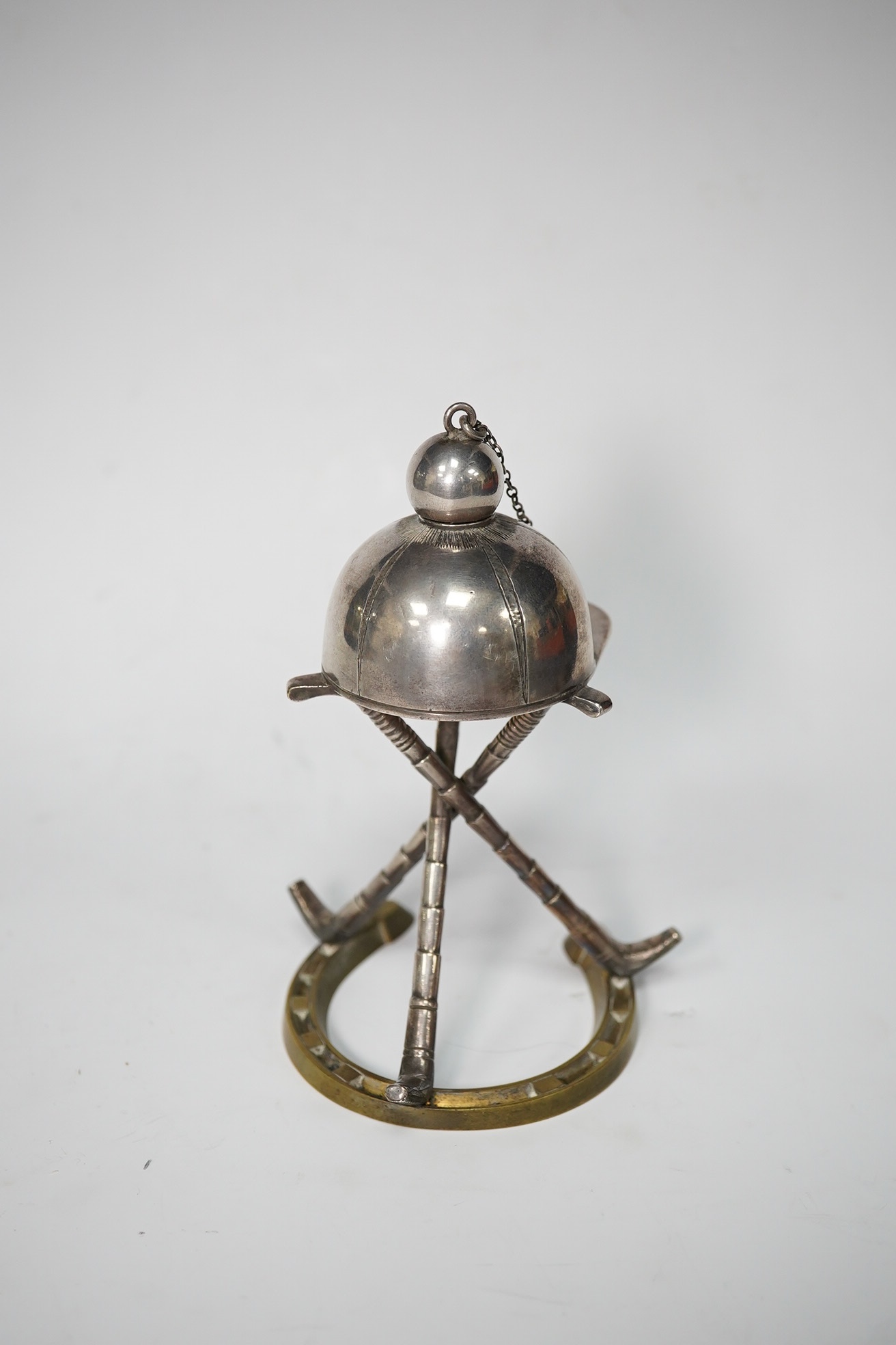 A late Victorian 'equestrian theme' silver plated novelty club lighter, modelled with a riding hat, crops and a horseshoe, 11.7cm. Condition - good